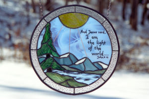 Stained glass panel with sunrise and bible verse